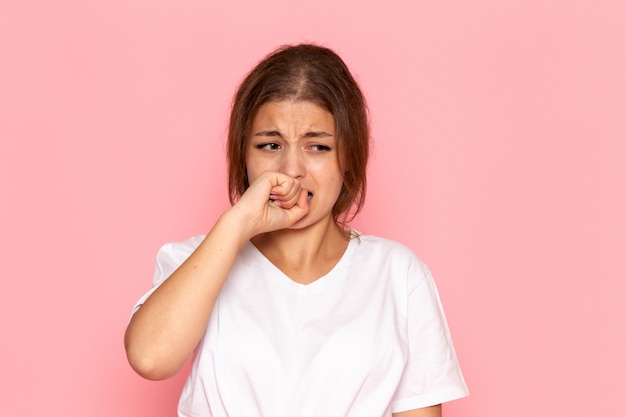 Una vista frontal joven y bella mujer en camisa blanca con expresión triste y asustada