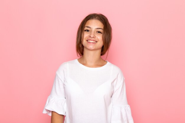 Una vista frontal joven y bella mujer en camisa blanca posando