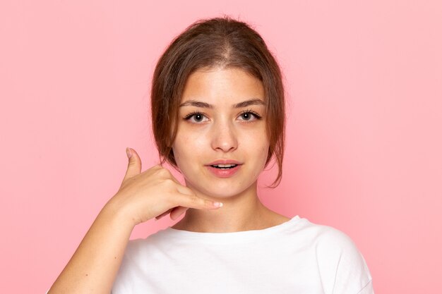 Una vista frontal joven y bella mujer en camisa blanca posando