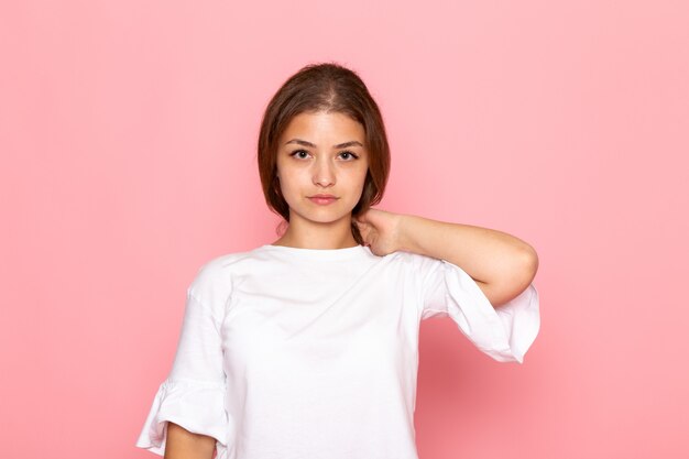 Una vista frontal joven y bella mujer en camisa blanca posando