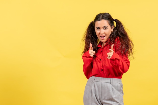 Vista frontal joven en blusa roja con lindo cabello y linda cara sobre fondo amarillo inocencia niño niña color juvenil