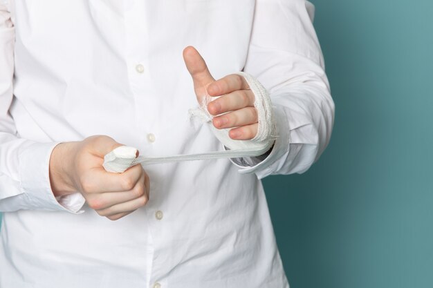 Una vista frontal joven en camisa blanca sobre el escritorio azul