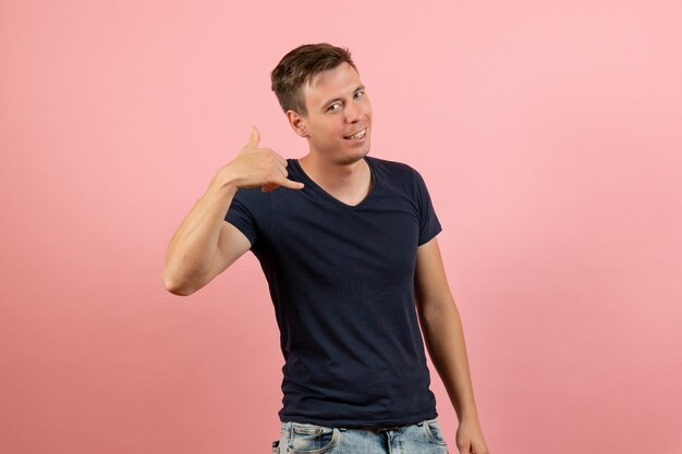 Vista frontal joven en camiseta azul posando sobre fondo rosa claro emoción modelo de color humano masculino