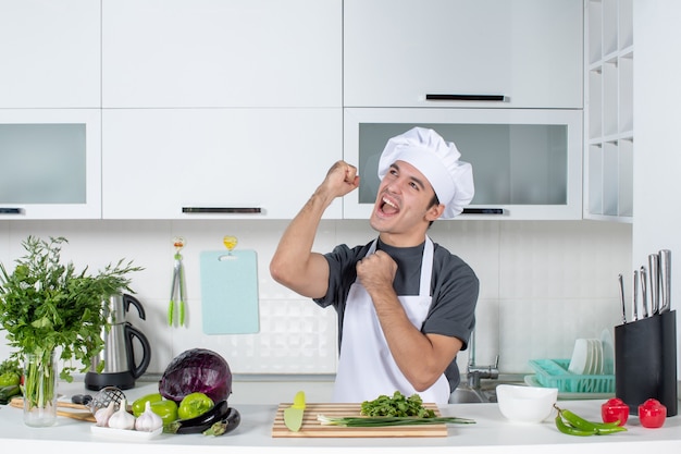 Vista frontal joven chef en uniforme expresando su felicidad