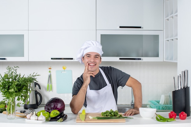 Foto gratuita vista frontal joven chef en uniforme sonriendo