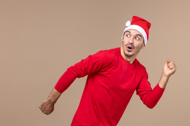 Foto gratuita vista frontal joven corriendo con expresión emocionada sobre fondo marrón emoción vacaciones macho