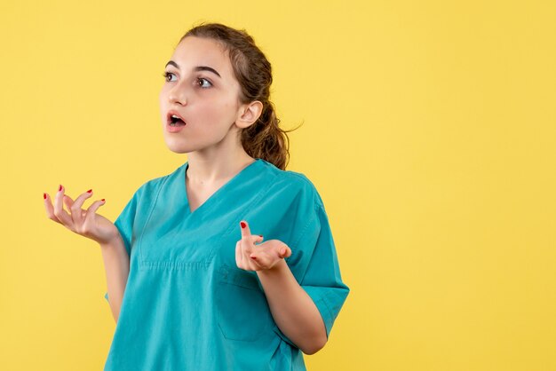 Foto gratuita vista frontal de la joven doctora en camisa médica en la pared amarilla