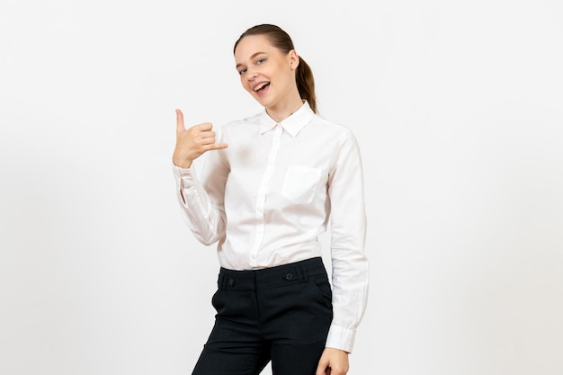 Vista frontal joven en elegante blusa blanca posando sobre fondo blanco mujer trabajo de oficina señora trabajadora