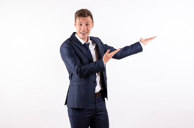 Vista frontal joven en elegante traje clásico sonriendo sobre fondo blanco.