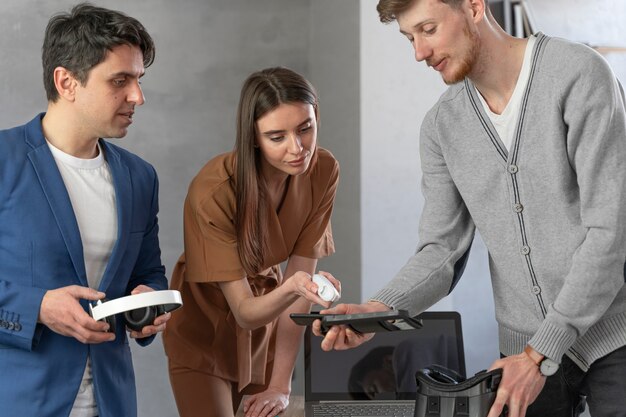 Vista frontal del joven equipo de profesionales que trabajan con portátiles y auriculares