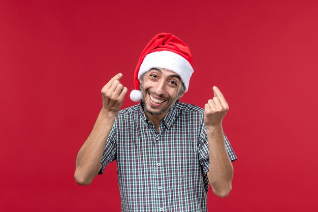 Vista frontal joven con expresión feliz en la pared roja vacaciones año nuevo rojo