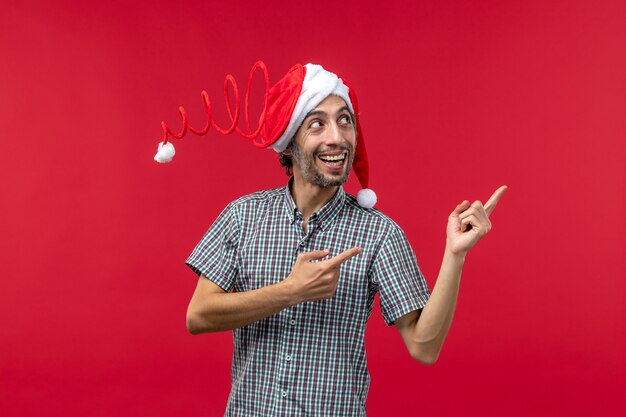 Foto gratuita vista frontal del joven con expresión sonriente en la pared roja