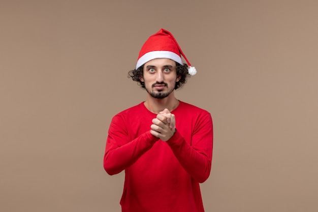 Vista frontal joven con expresión tranquila sobre fondo marrón vacaciones emoción navidad