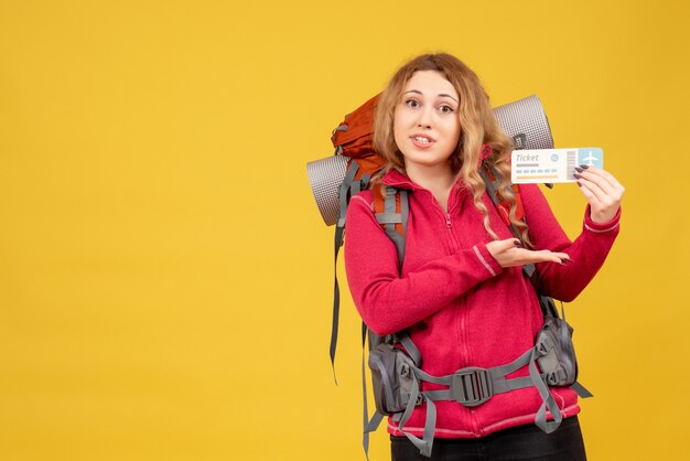 Vista frontal de la joven feliz viajando satisfecha en máscara médica con boleto