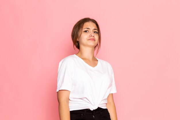 Una vista frontal joven hermosa mujer en camisa blanca con posando con expresión escéptica