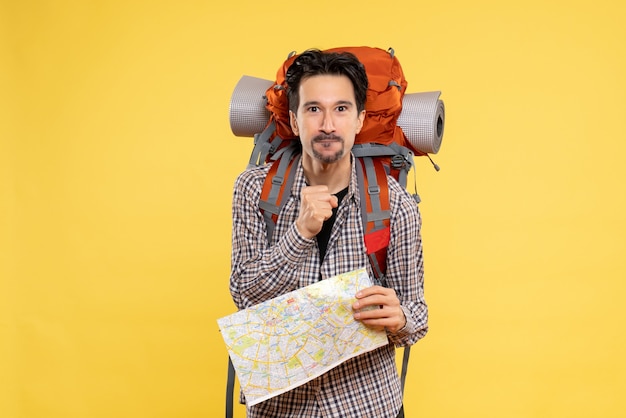 Foto gratuita vista frontal joven hombre yendo de excursión con mochila sosteniendo mapa sobre fondo amarillo viaje aire naturaleza empresa campus bosque color