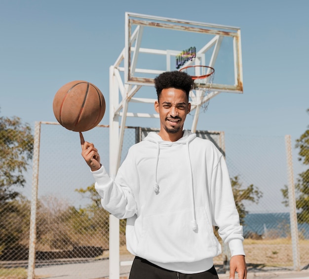 Vista frontal joven jugando baloncesto al aire libre