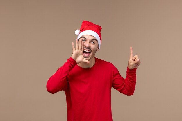 Vista frontal joven macho gritando sobre fondo marrón Navidad emoción vacaciones macho