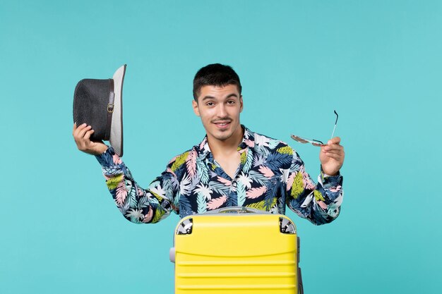 Vista frontal del joven macho con su bolsa amarilla preparándose para un largo viaje sobre la superficie azul