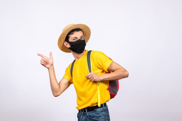 Foto gratuita vista frontal joven con máscara y camiseta amarilla apuntando algo