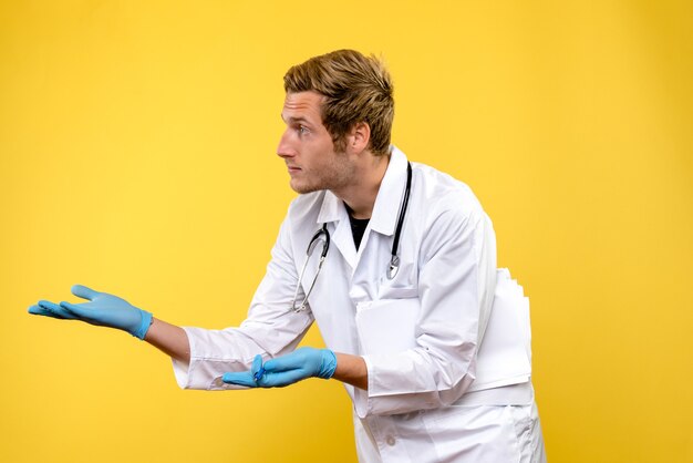 Vista frontal joven médico hablando con alguien sobre fondo amarillo médico de salud del hospital