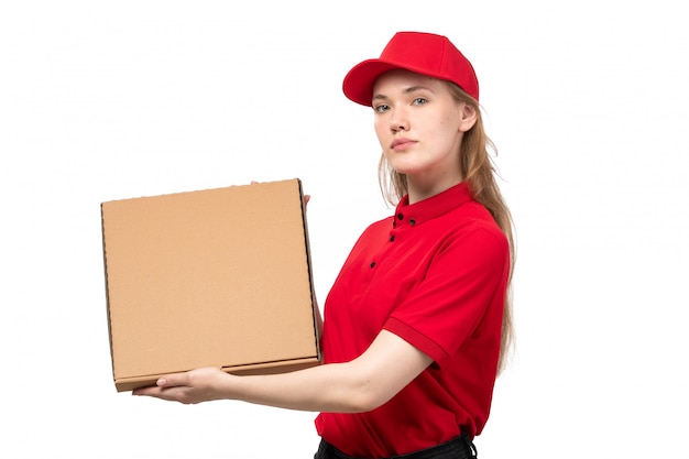 Una vista frontal joven mensajero femenino trabajadora del servicio de entrega de alimentos con caja de entrega en blanco