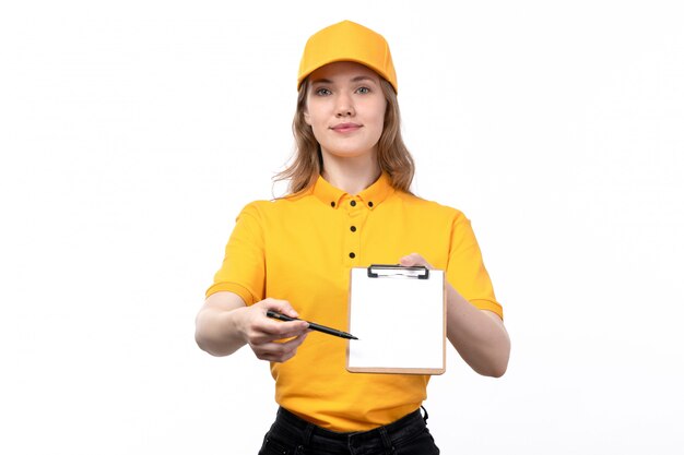 Una vista frontal joven mensajero trabajadora del servicio de entrega de alimentos sonriendo sosteniendo el bloc de notas para firmas en blanco