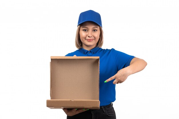 Una vista frontal joven mensajero en uniforme azul con paquete de entrega de alimentos