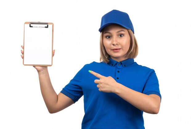 Una vista frontal joven mensajero en uniforme azul sosteniendo el bloc de notas para firmas