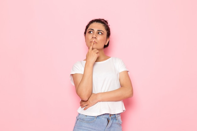 Una vista frontal joven mujer en camiseta blanca y blue jeans soñando despierto y pensando