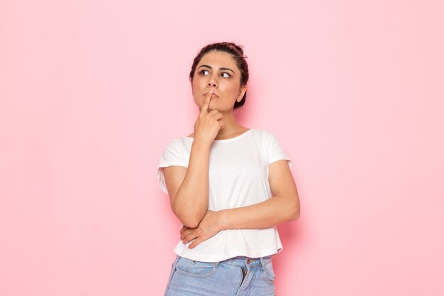 Una vista frontal joven mujer en camiseta blanca y blue jeans soñando despierto y pensando