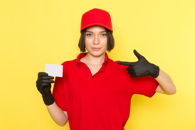 Una vista frontal joven mujer mensajero en rojo uniforme guantes negros y gorra roja