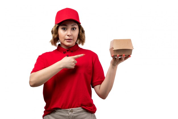 Una vista frontal joven mujer mensajero trabajadora del servicio de entrega de alimentos con paquete de alimentos en blanco