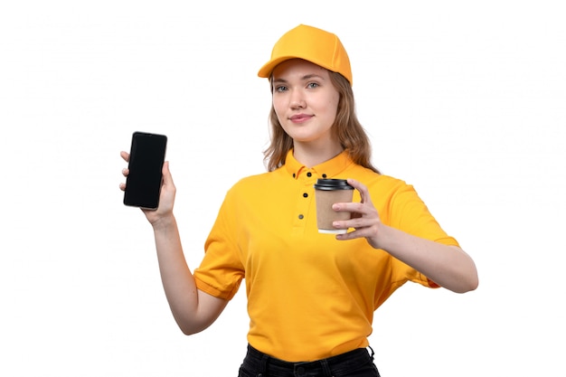 Foto gratuita una vista frontal joven mujer mensajero trabajadora del servicio de entrega de alimentos sonriendo sosteniendo smartphone y taza de café en blanco