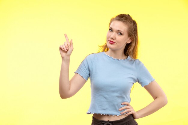 Una vista frontal joven mujer moderna en camisa azul pantalón negro feliz expresión sonriente posando