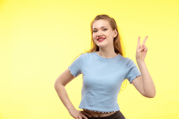 Una vista frontal joven mujer moderna en camisa azul pantalón negro feliz expresión sonriente posando