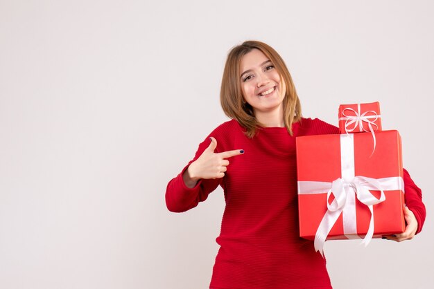 Vista frontal joven mujer con regalos de Navidad