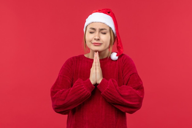 Vista frontal joven mujer rezando, vacaciones de Navidad rojo