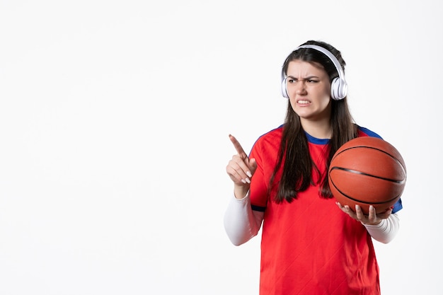 Vista frontal joven mujer en ropa deportiva con baloncesto