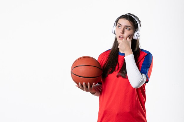 Vista frontal joven mujer en ropa deportiva con baloncesto