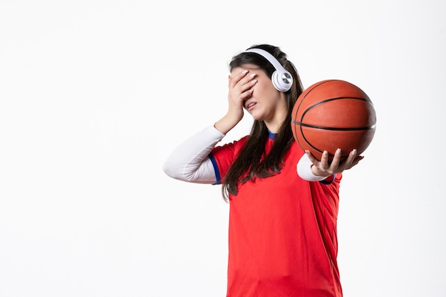 Vista frontal joven mujer en ropa deportiva con baloncesto