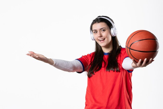 Vista frontal joven mujer en ropa deportiva con baloncesto