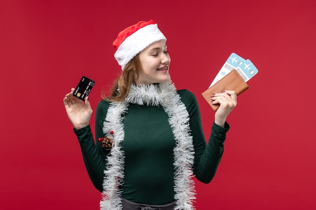 Foto gratuita vista frontal joven mujer sosteniendo billetes de tarjeta bancaria sobre fondo rojo.