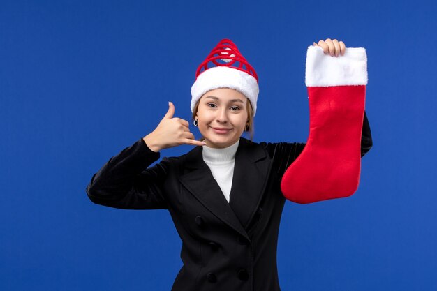 Foto gratuita vista frontal joven mujer sosteniendo un calcetín de navidad en la pared azul vacaciones año nuevo humano