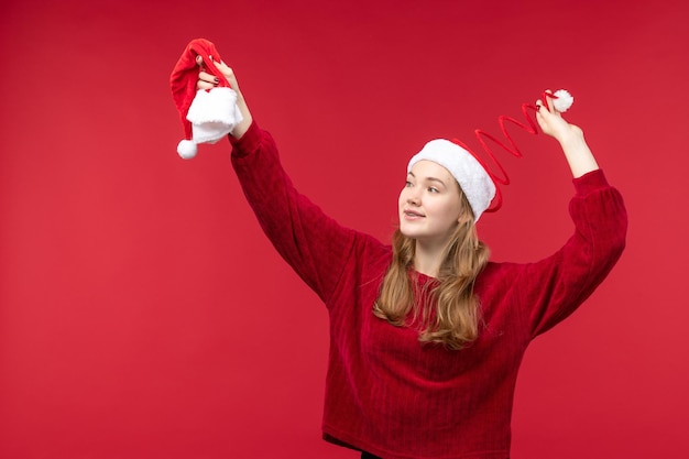 Vista frontal joven mujer sosteniendo gorro rojo, vacaciones de navidad navidad