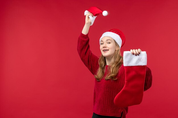 Vista frontal joven mujer sosteniendo gran calcetín y gorra, vacaciones de navidad