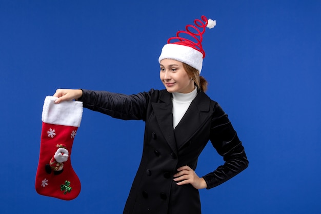 Foto gratuita vista frontal joven mujer sosteniendo gran calcetín de navidad en el escritorio azul vacaciones de fin de año