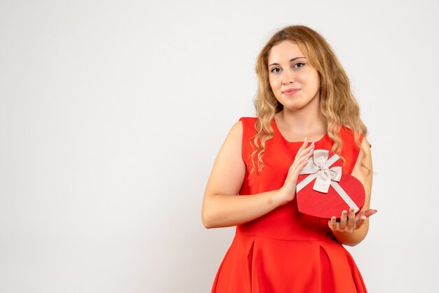 Vista frontal joven mujer sosteniendo presente en forma de corazón