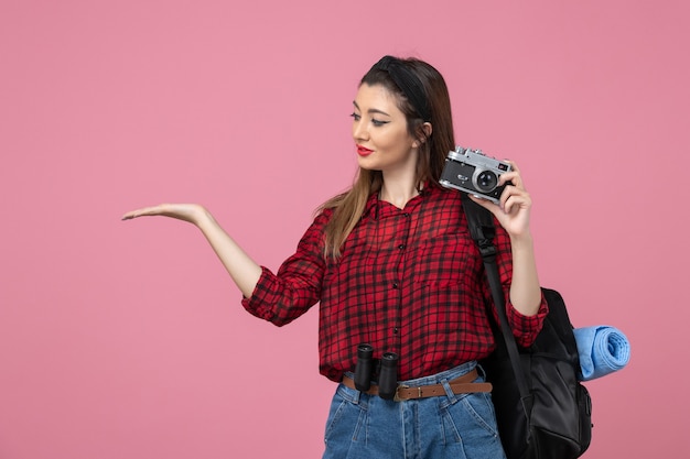 Foto gratuita vista frontal joven mujer tomando fotografías con cámara sobre fondo rosa modelo de mujer de fotografía