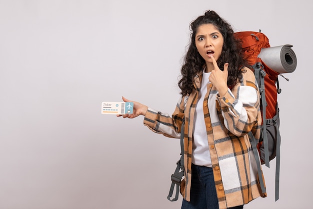 Vista frontal joven mujer yendo de excursión con billete de avión sobre fondo blanco aire turístico bosque vacaciones vuelo viaje campus montaña